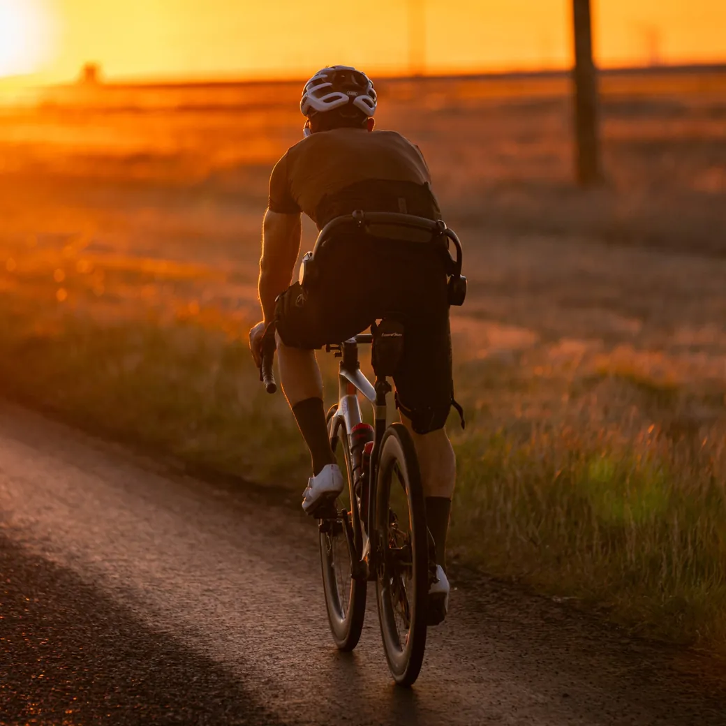 Cycliste sur route au coucher du soleil, équipé d’un exosquelette Hypershell